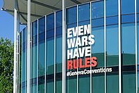Rundes Gebäude gegenüber dem Internationalen Kommitee des Roten Kreuzes mit der Aufschrift "Even wars have rules" 